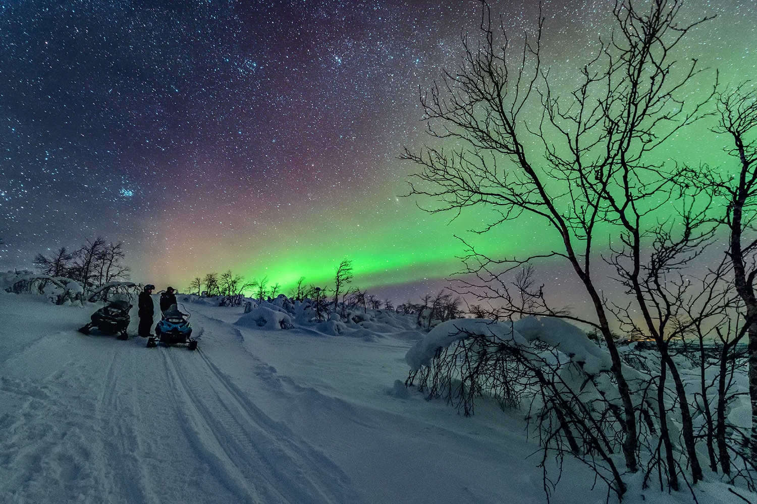 Snow mobiling under auroras